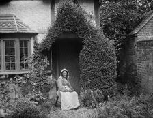 Portrait of an unknown elderly woman sitting outside her cottage, West Ilsley, West Berkshire, 1900. Creator: Henry Taunt