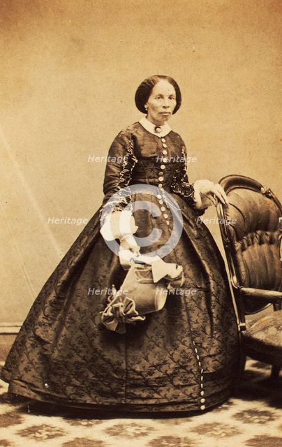 Portrait of older woman, standing, holding bonnet, c1860. Creator: CK Bill.