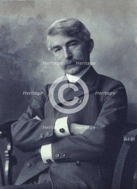 Portrait of man wearing a pinstripe suit seated with his arms crossed, c1900. Creator: Fannie L. Elton.