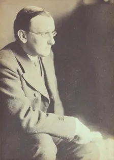 Portrait of man wearing glasses, seated with elbow resting on right knee , c1900. Creator: Eva Watson-Schutze