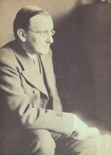 Portrait of man wearing glasses, seated with elbow resting on right knee , c1900. Creator: Eva Watson-Schutze