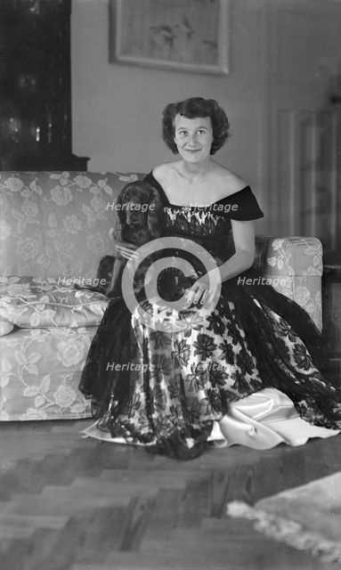 Portrait of seated woman in evening dress with her dog, c1935.  Creator: Kirk & Sons of Cowes.