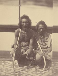 Portrait of Two Native Men Sitting on a Boat Holding Long Curved Sticks, 1865. Creator: Théodule Deveria