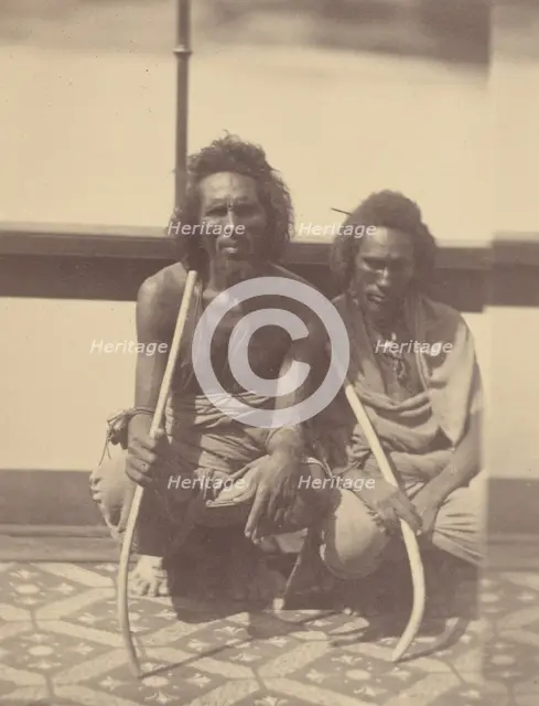 Portrait of Two Native Men Sitting on a Boat Holding Long Curved Sticks, 1865. Creator: Théodule Deveria.