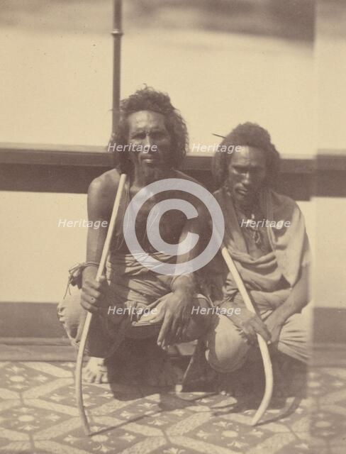 Portrait of Two Native Men Sitting on a Boat Holding Long Curved Sticks, 1865. Creator: Théodule Deveria.