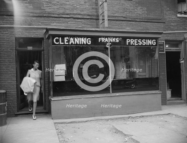 Possibly: A tailor in Frank's cleaning and pressing establishment checking..., Washington, DC, 1942. Creator: Gordon Parks.