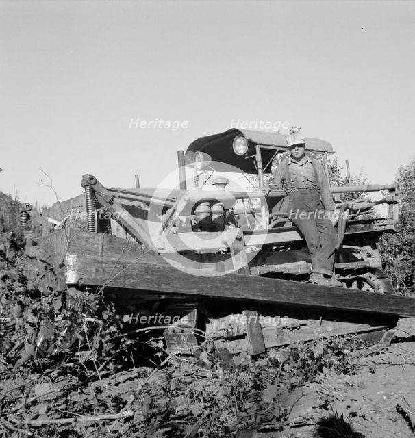 Possibly: Bulldozer raises and pushes stump on cut-over farm, Lewis County, Western Washington, 1939 Creator: Dorothea Lange.