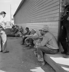 Possibly: Idle men seated in shade on the other side..., Tulelake, Siskiyou County, California, 1939 Creator: Dorothea Lange