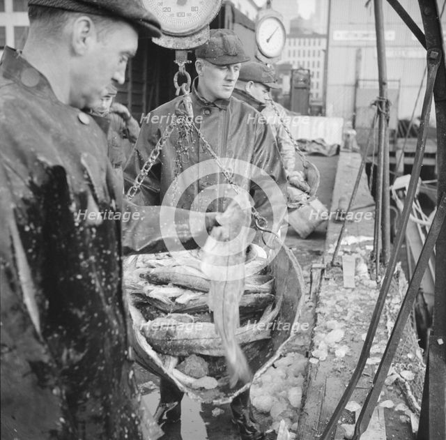 Possibly: New England fishermen unloading fish at the Fulton fish market, New York, 1943. Creator: Gordon Parks.
