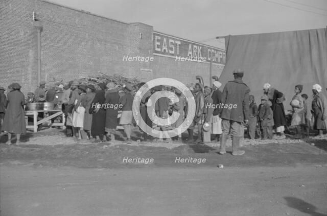 Possibly: Negroes at mealtime in the flood refugee camp, Forrest City, Arkansas, 1937. Creator: Walker Evans.