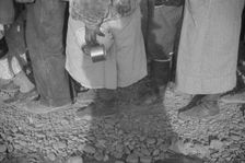 Possibly: Negroes at mealtime in the flood refugee camp, Forrest City, Arkansas, 1937. Creator: Walker Evans