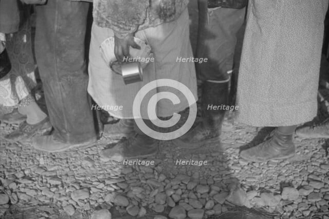 Possibly: Negroes at mealtime in the flood refugee camp, Forrest City, Arkansas, 1937. Creator: Walker Evans.