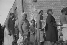 Possibly: Negroes in the lineup for food at the flood refugee camp, Forrest City, Arkansas, 1937. Creator: Walker Evans