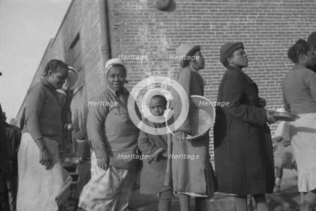 Possibly: Negroes in the lineup for food at the flood refugee camp, Forrest City, Arkansas, 1937. Creator: Walker Evans.