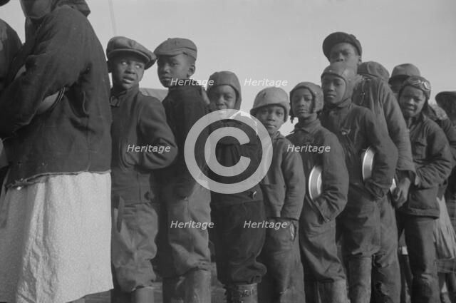 Possibly: Negroes in the lineup for food at the flood refugee camp, Forrest City, Arkansas, 1937. Creator: Walker Evans.