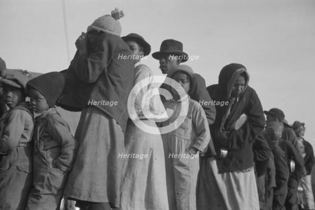 Possibly: Negroes in the lineup for food at the flood refugee camp, Forrest City, Arkansas, 1937. Creator: Walker Evans.
