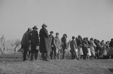 Possibly: Negroes in the lineup for food at the flood refugee camp, Forrest City, Arkansas, 1937. Creator: Walker Evans