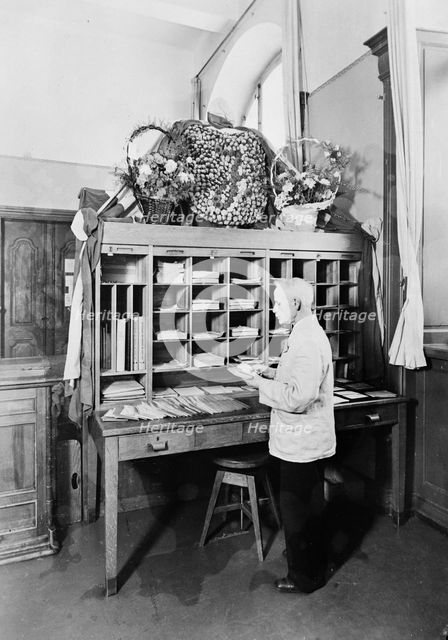 Postman sorting mail at the post office, Landskrona, Sweden, 1940. Creator: Unknown.