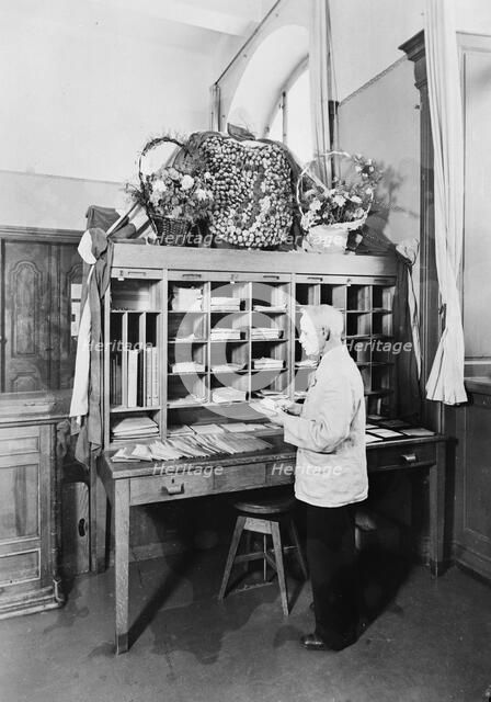 Postman sorting mail at the post office, Landskrona, Sweden, 1940. Artist: Unknown