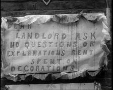 Poster Hanging on Wall Reading DEAR LANDLORD ASK NO QUESTIONS OR EXPLANATIONS RENT SPENT..., 1937. Creator: British Pathe Ltd