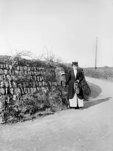 Postwoman emptying a postbox at an unidentified location in Kerrier, Cornwall, 1901. Artist: Alfred Newton & Sons