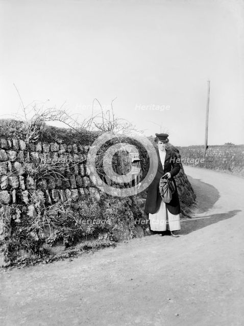 Postwoman emptying a postbox at an unidentified location in Kerrier, Cornwall, 1901. Artist: Alfred Newton & Sons.