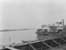Paddle wheel steamboat on river, New Orleans, between 1920 and 1926. Creator: Arnold Genthe