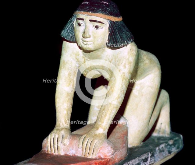 Painted figure of an Egyptian servant making bread. Artist: Unknown