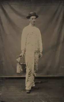 Painter in Paint-spattered Overalls with Brushes and Paint Can, 1870s-80s. Creator: Unknown