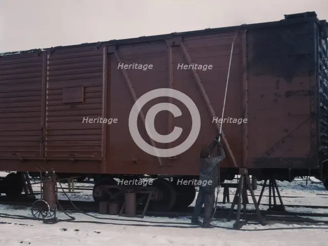 Painting a car at the repair or "rip" tracks at North Proviso(?), C & NW RR, Chicago, Ill., 1942. Creator: Jack Delano.