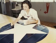 Painting the American insignia on airplane wings is a job that Mrs..., Corpus Christi, Texas, 1942. Creator: Howard Hollem