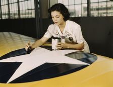 Painting the American insignia on airplane wings is a job...Air Base, Corpus Christi, Texas, 1942. Creator: Howard Hollem