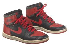 Pair of red and black Air Jordan I high top sneakers made by Nike, 1985. Creator: Nike