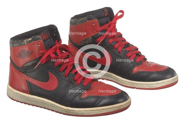 Pair of red and black Air Jordan I high top sneakers made by Nike, 1985. Creator: Nike.