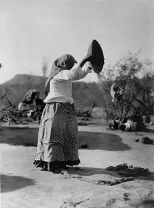 Papago cleaning wheat (Winnowing wheat), c1907. Creator: Edward Sheriff Curtis