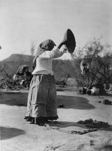 Papago cleaning wheat (Winnowing wheat), c1907. Creator: Edward Sheriff Curtis