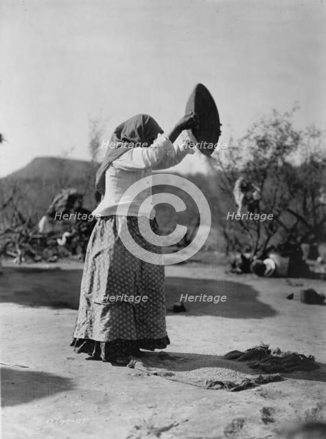 Papago cleaning wheat (Winnowing wheat), c1907. Creator: Edward Sheriff Curtis.