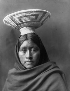 Papago Indian, Luzi, head-and-shoulders portrait, facing front, with a basket tray on her head,c1907 Creator: Edward Sheriff Curtis