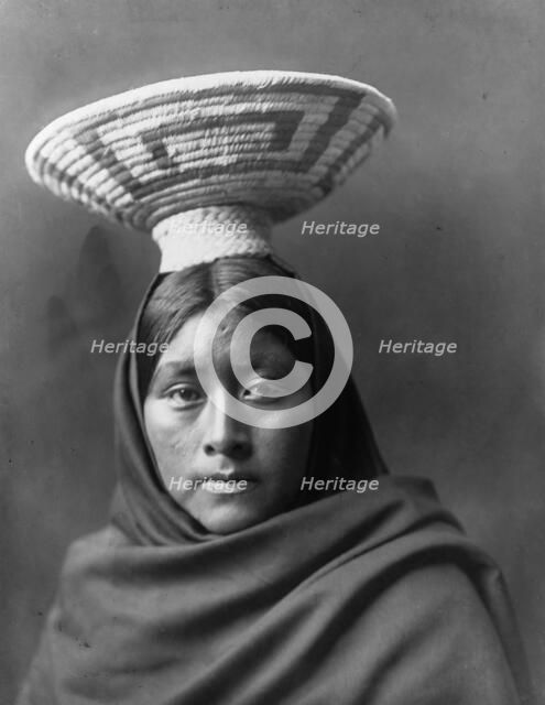 Papago Indian, Luzi, head-and-shoulders portrait, facing front, with a basket tray on her head,c1907 Creator: Edward Sheriff Curtis.