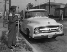 Parking meter with Los Angeles parking control officer 1958. Creator: Unknown