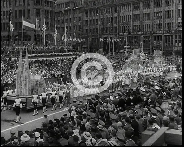 Participants Walking Alongside Floats in a Large Parade During the World Congress for..., 1938. Creator: British Pathe Ltd.