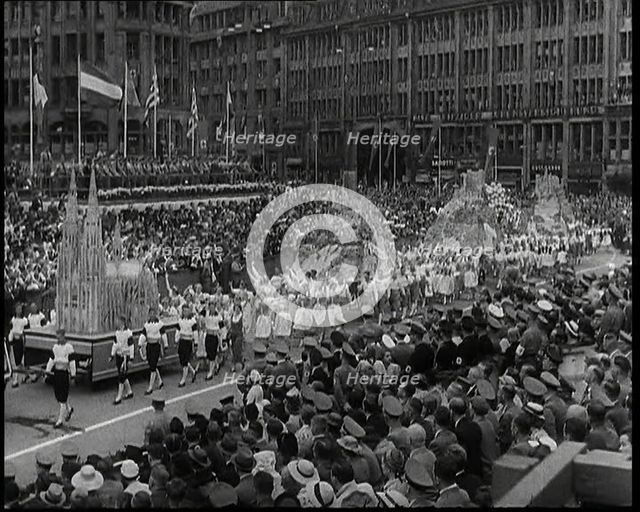 Participants Walking Alongside Floats in a Large Parade During the World Congress for..., 1938. Creator: British Pathe Ltd.