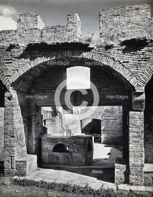 Partly ruined buildings in Ostia identified as a tavern or hot-food shop (thermopolium)..., 1920-9. Creator: Domenico Anderson.