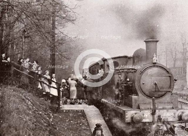 Passengers queuing for a steam rain at Rowntree's halt, York, Yorkshire, 1934. Artist: Unknown