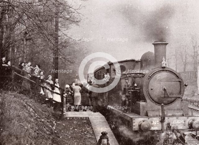 Passengers queuing for a steam rain at Rowntree's halt, York, Yorkshire, 1934. Artist: Unknown