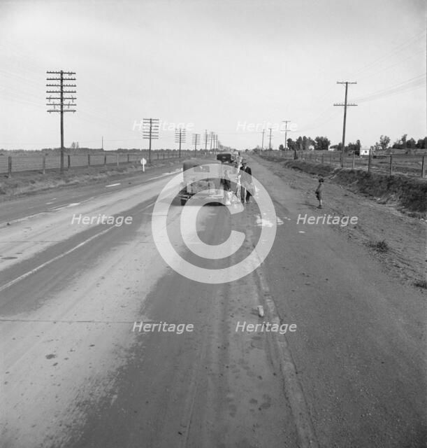 Passing motorist gives walking family of seven a lift to the next town, California, 1939. Creator: Dorothea Lange.