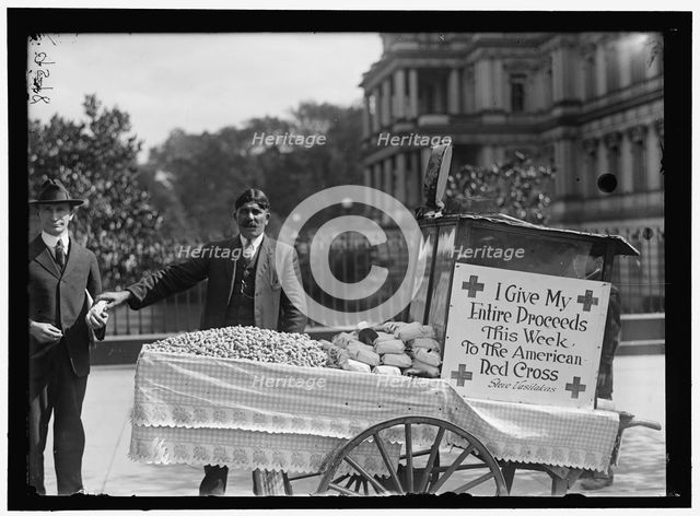 Peanut vendor Steve Vasilakas standing near his cart..., between 1916 and 1918. Creator: Harris & Ewing.