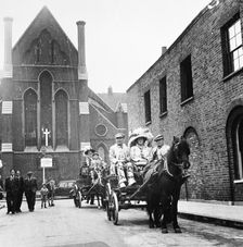 Pearly king and queen riding through London in a carriage, c1950s