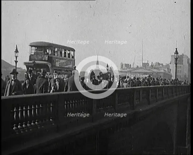Pedestrians And Commuters Crossing London Bridge With Buses in the Background, 1920s. Creator: British Pathe Ltd.