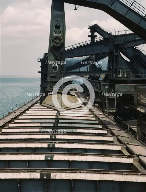 Pennsylvania R.R. iron ore docks, unloading ore from a lake freighter...ore unloaders, 1943. Creator: Jack Delano.